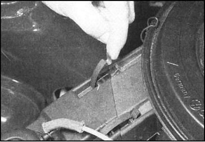 затем отпустите два пружинных фиксатора...